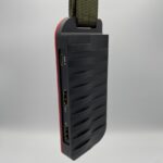 a black and red device hanging from a cord