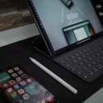 black laptop computer turned on beside white pen