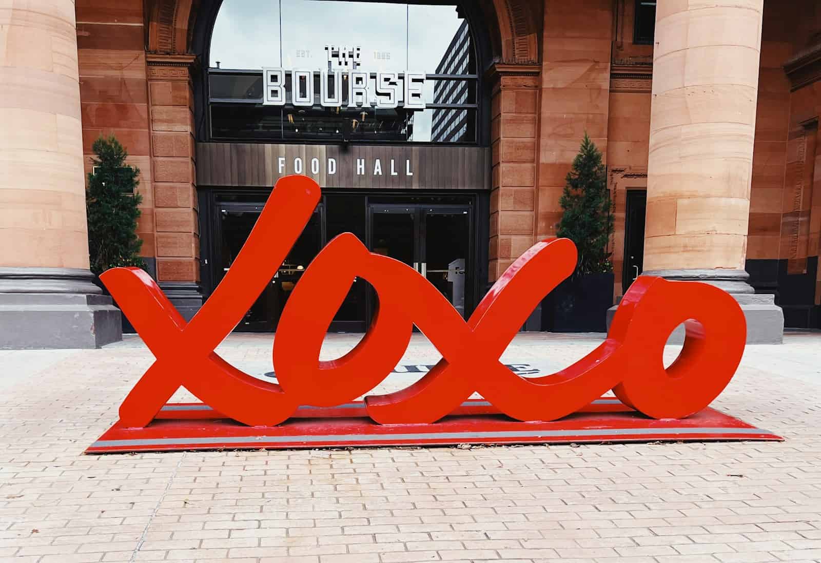 a large red xoxo sign sitting in front of a building
