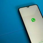 a white and black phone with a green whatsapp sticker on it