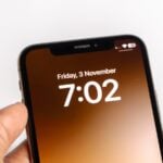 a person holding a cell phone with the time on it