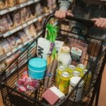 a person pushing a shopping cart full of food