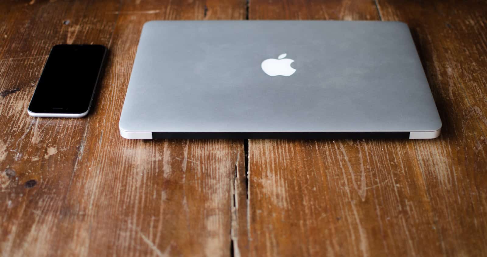 photo of MacBook Pro beside black Android smartphone