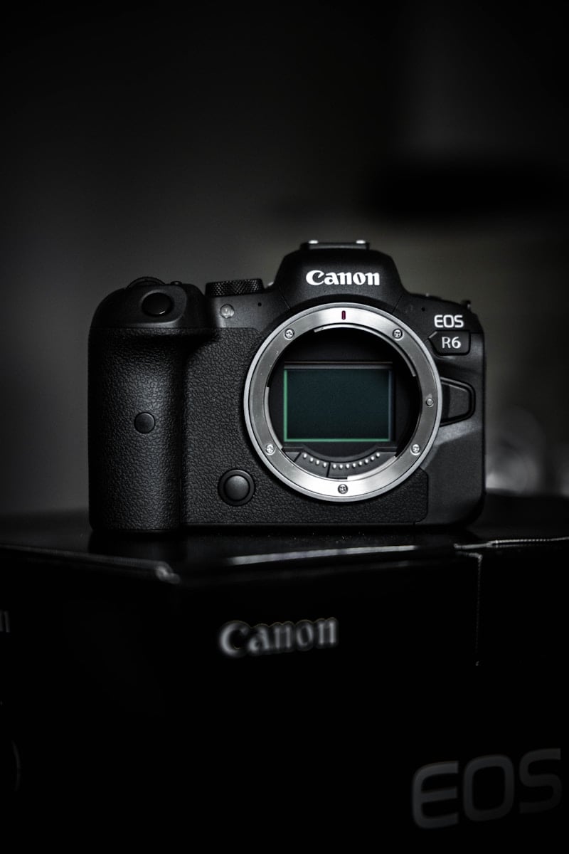 black canon dslr camera on black surface
