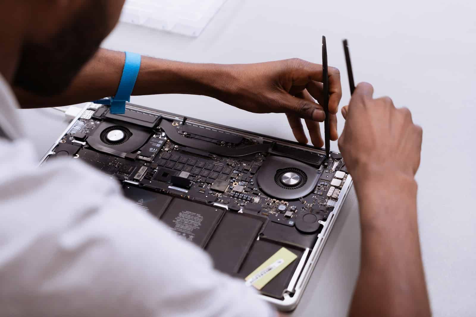 a man working on a laptop with a pair of scissors