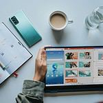 person using Windows 11 computer beside white ceramic mug on white table