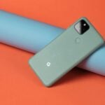 A cell phone laying on top of a blue tube