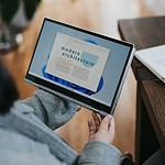 person in blue denim jeans holding Windows 11 tablet