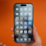 A person is holding an iPhone showcasing apps.