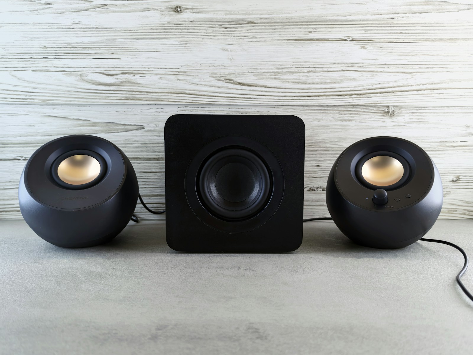 Three speakers sitting on top of a table