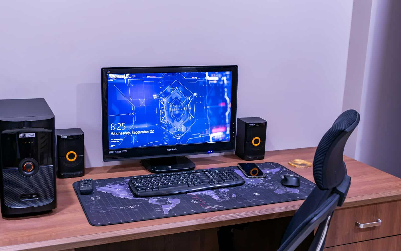 a desk with a computer and speakers on it