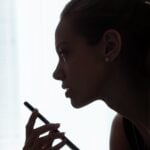 a woman is holding a pen and looking at something