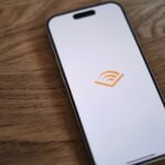 A cell phone sitting on top of a wooden table