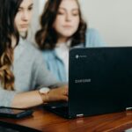 two woman using laptop