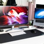 turned on MacBook Pro beside monitor on desk