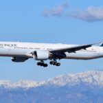 white passenger plane flying over snow covered mountain during daytime